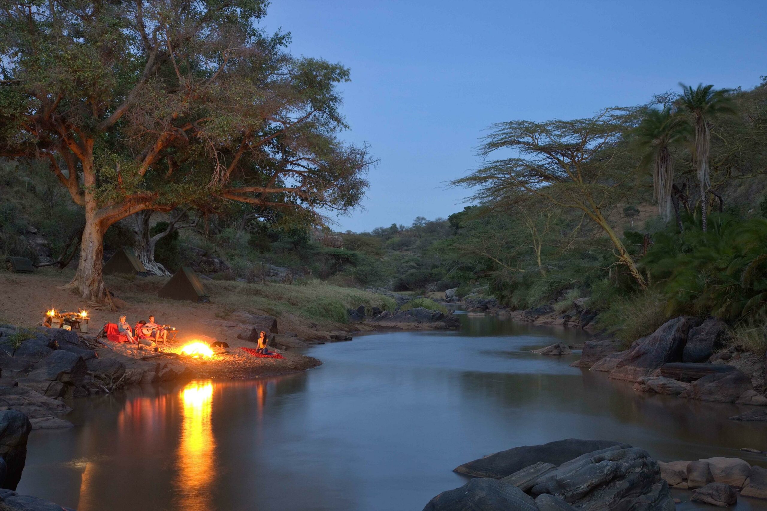 Ol Malov Activities, group on river bank around fire in Kenya