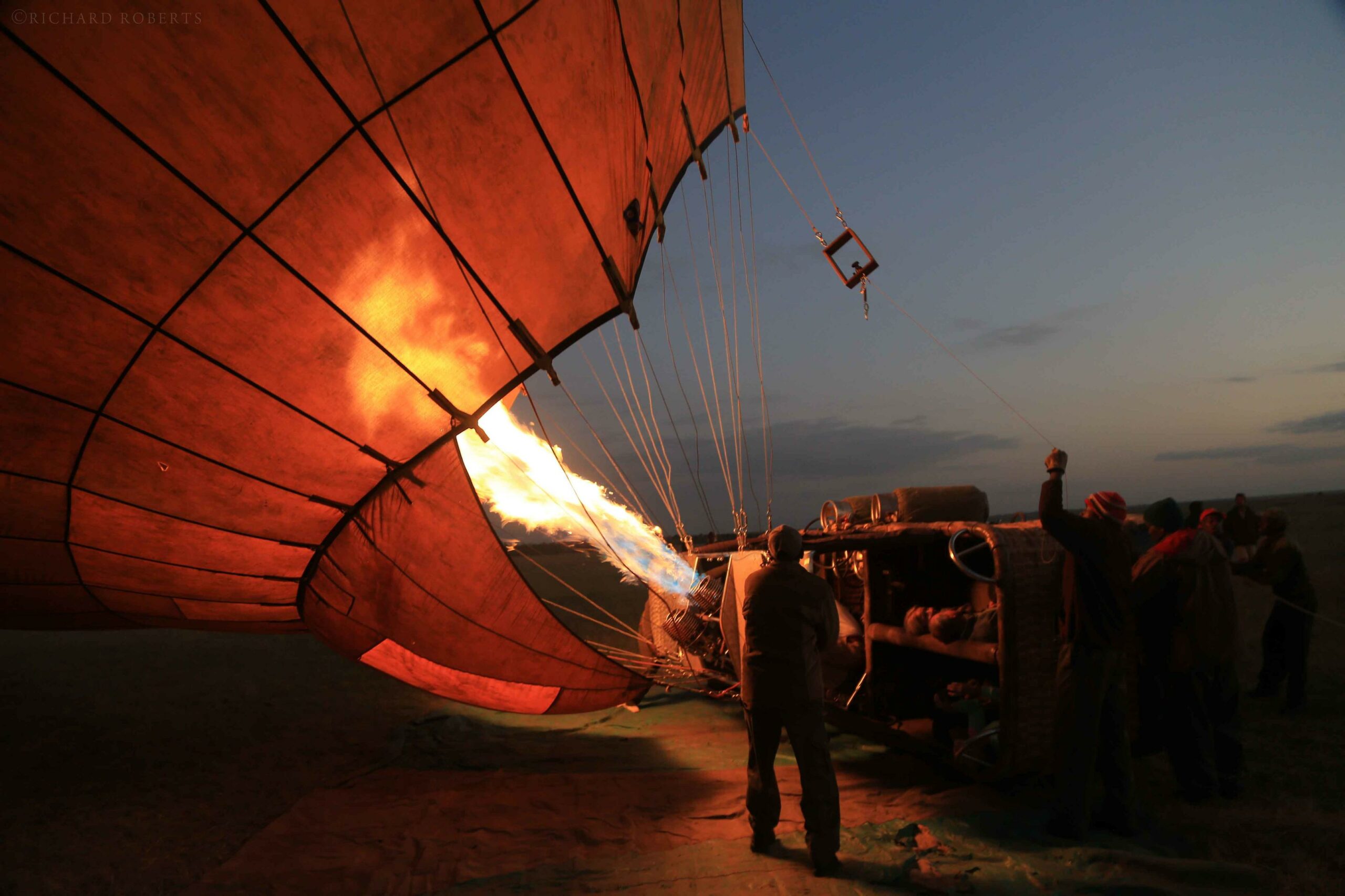 a group of people standing around a hot air balloon.