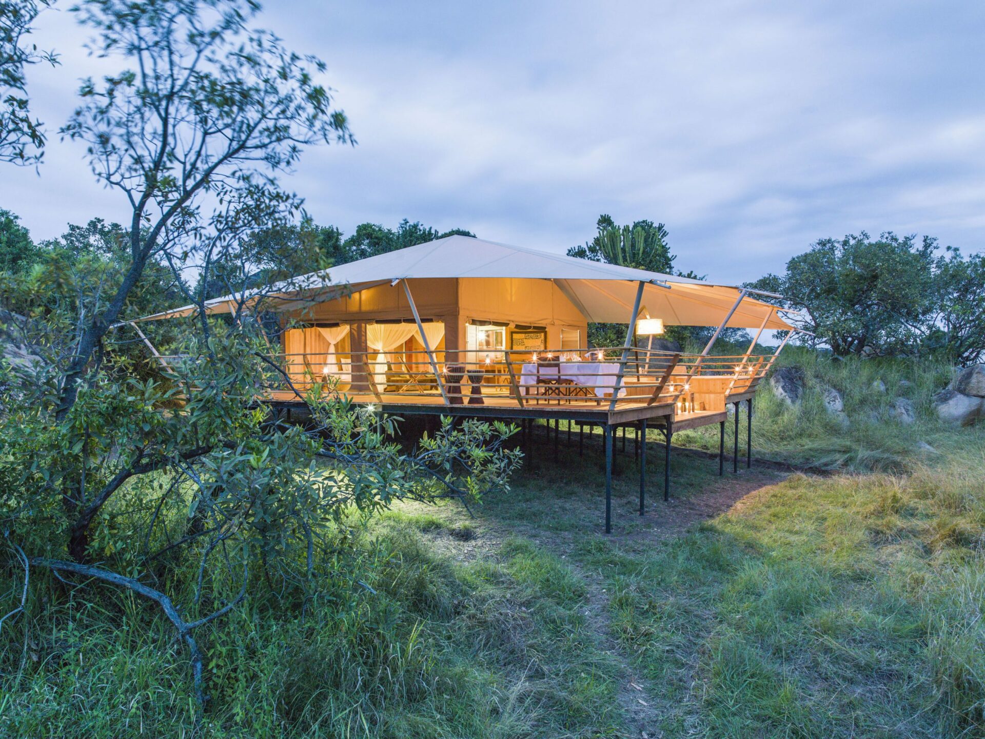 exterior of an accommodation tent at serengeti bushtops surrounded by bushes and trees on luxury Africa safari
