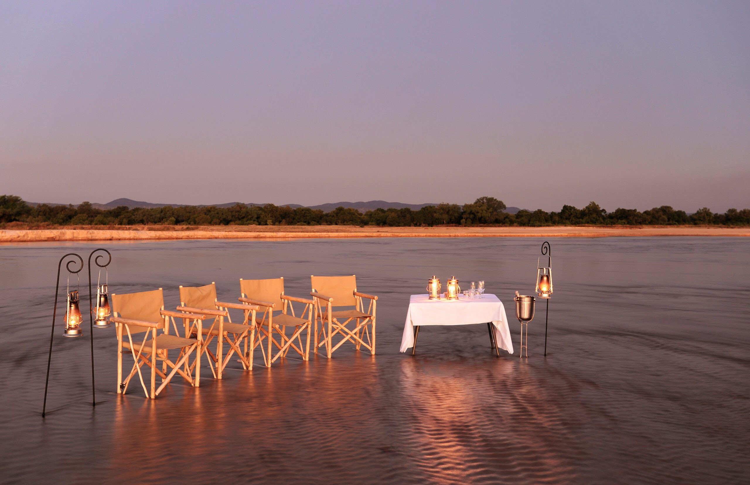 chairs and a table set up in the river for dining