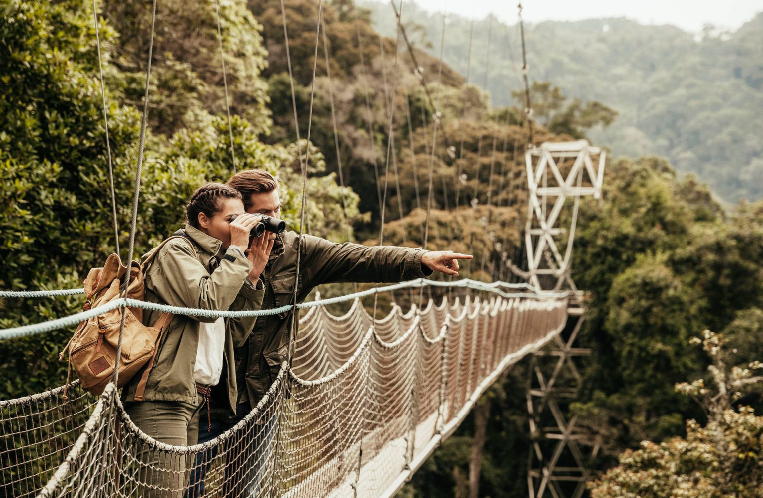 couple viewing and pointing from canopy at Nyungwe