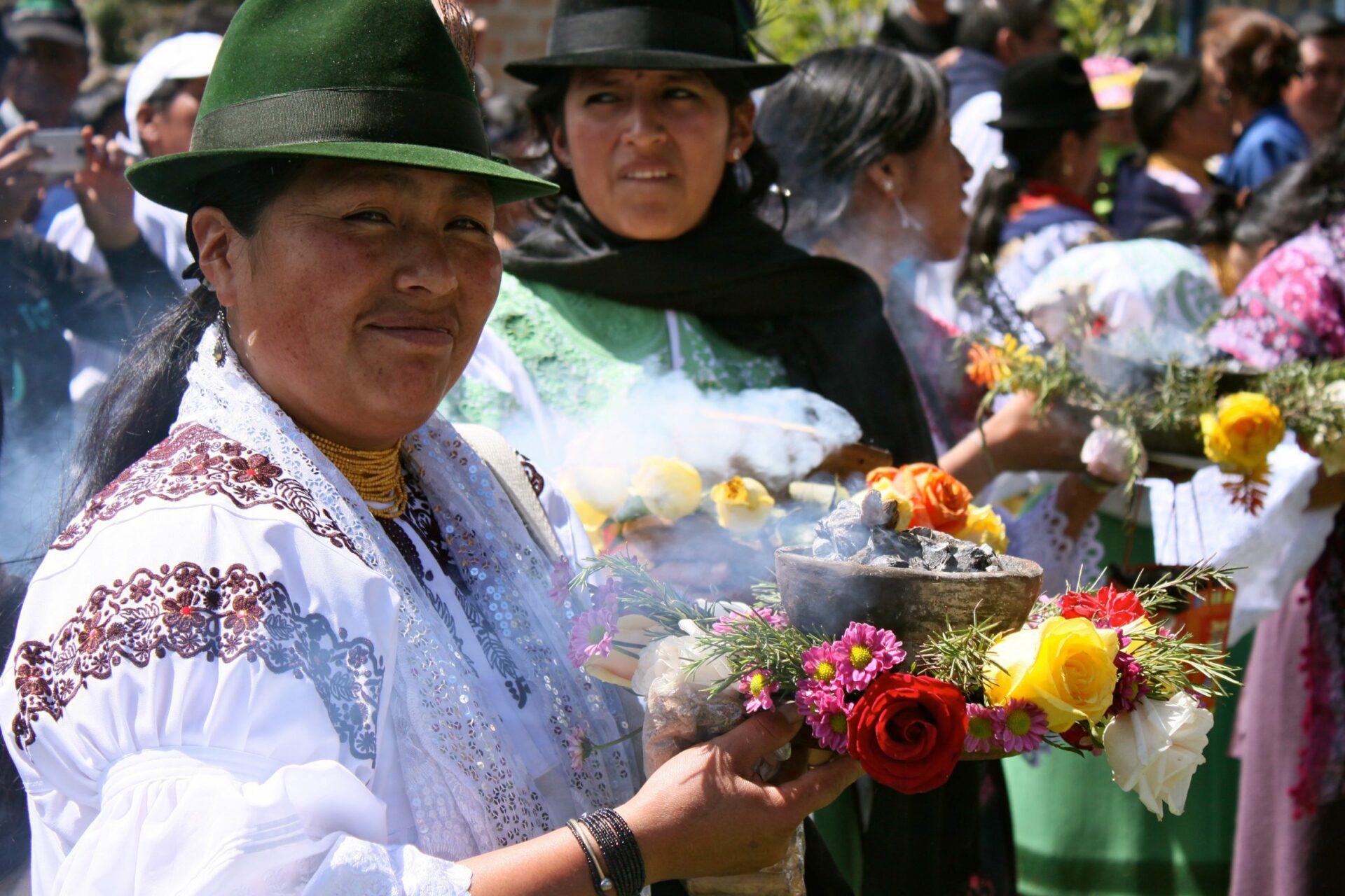 two women holding flowers at a marketplace