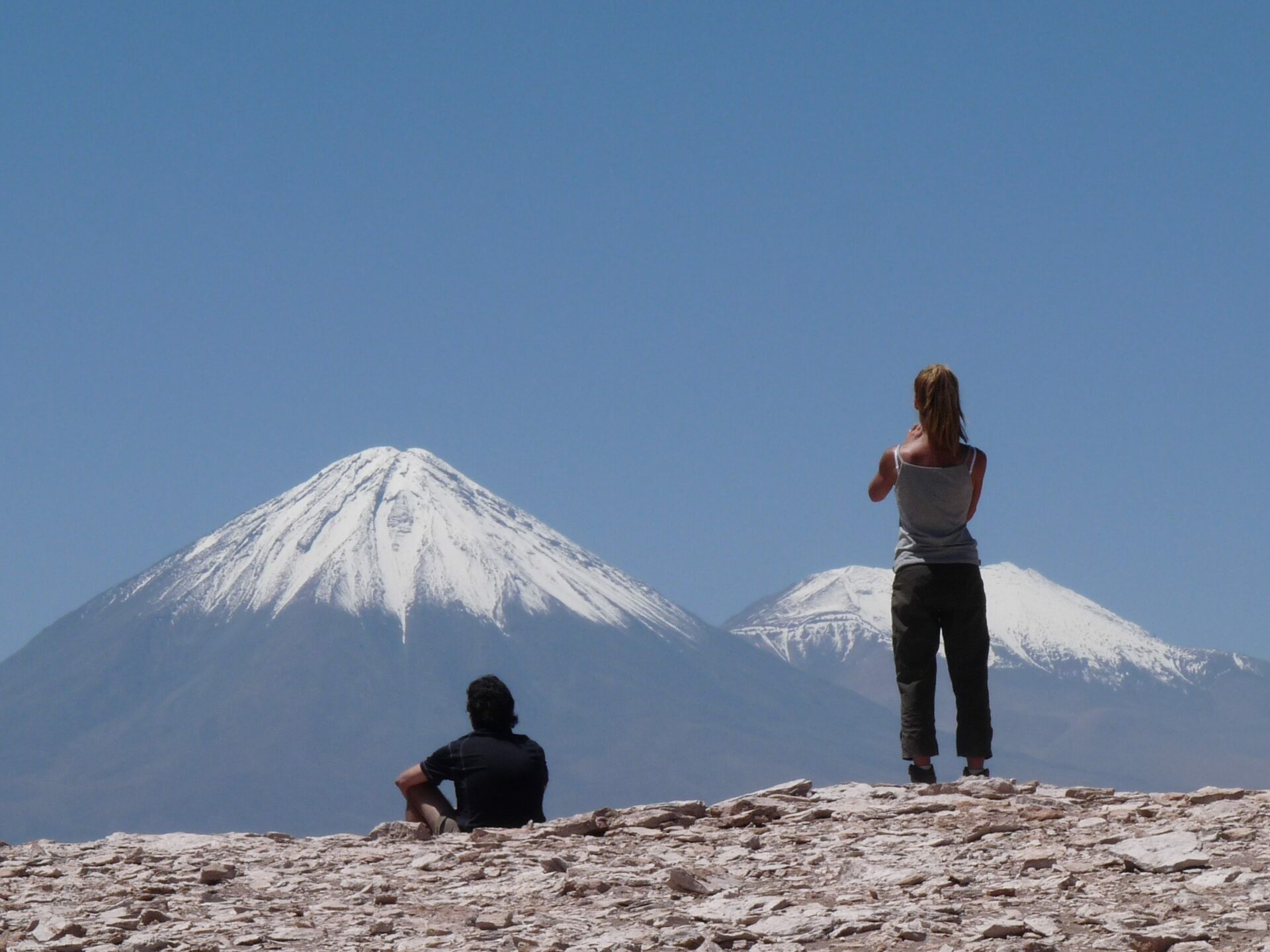 two people with snow capped mountains in the background