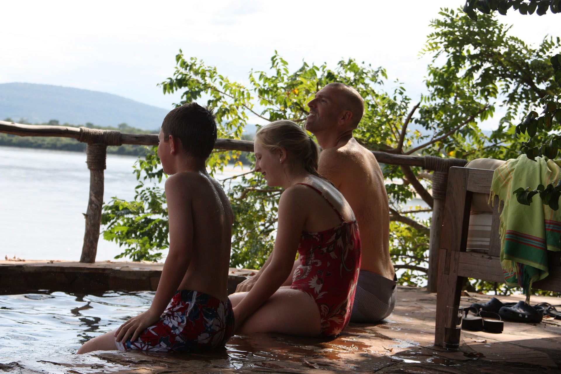a man and two children sitting in a hot tub.
