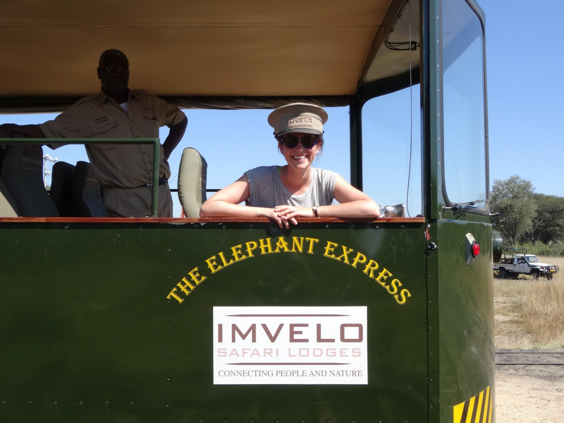 woman wearing an engineer's hat looking out the back of the Elephant Express