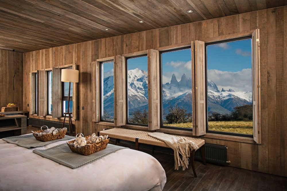 bed with glass windows and mountains