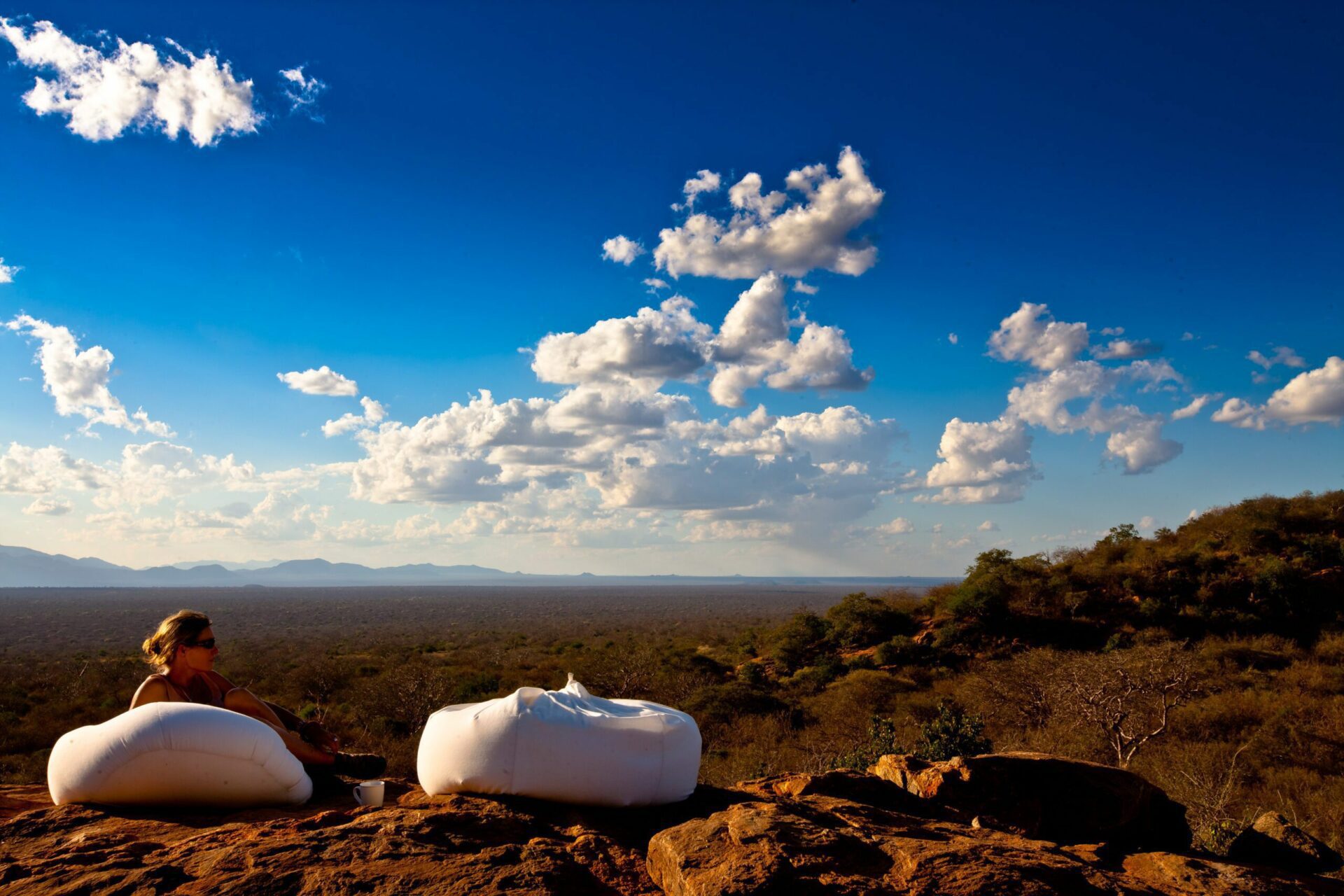 perfect blue sky with fluffy white clouds and two white bean bags set up to enjoy drinks.