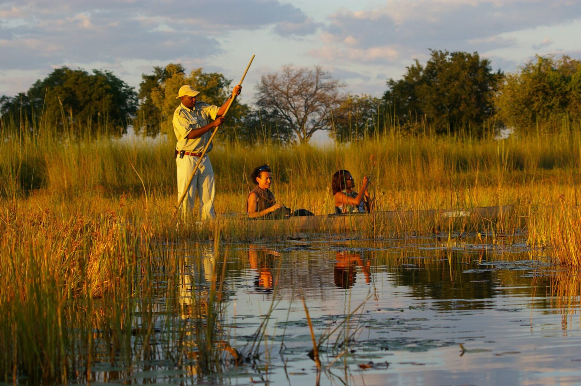 mokoro in the waterways of okavango delta at xugana camp with 2 people and 1 guide