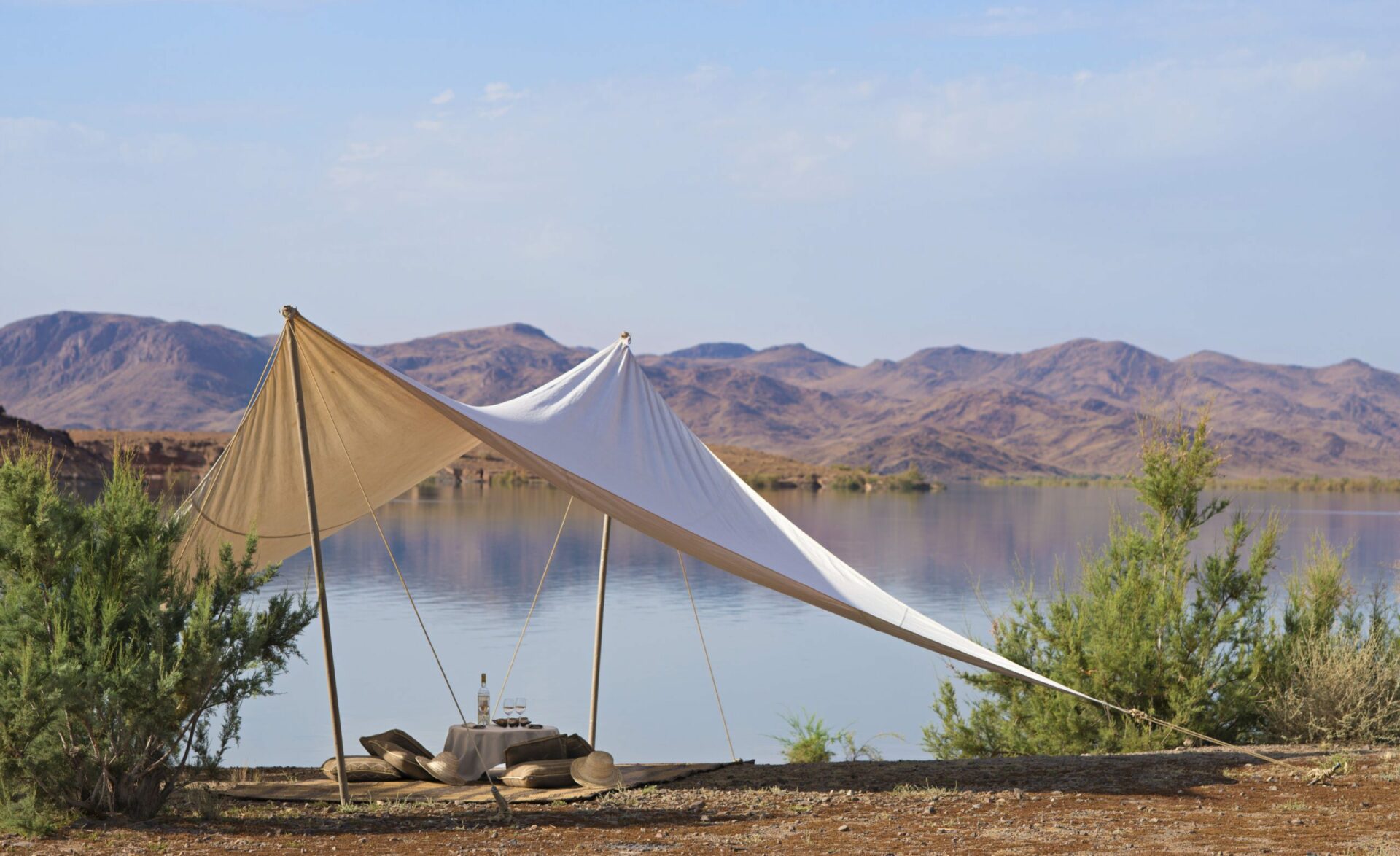 white cloth making a tent with bean bag chairs overlook a body of water and mountains at Dah Ahlam