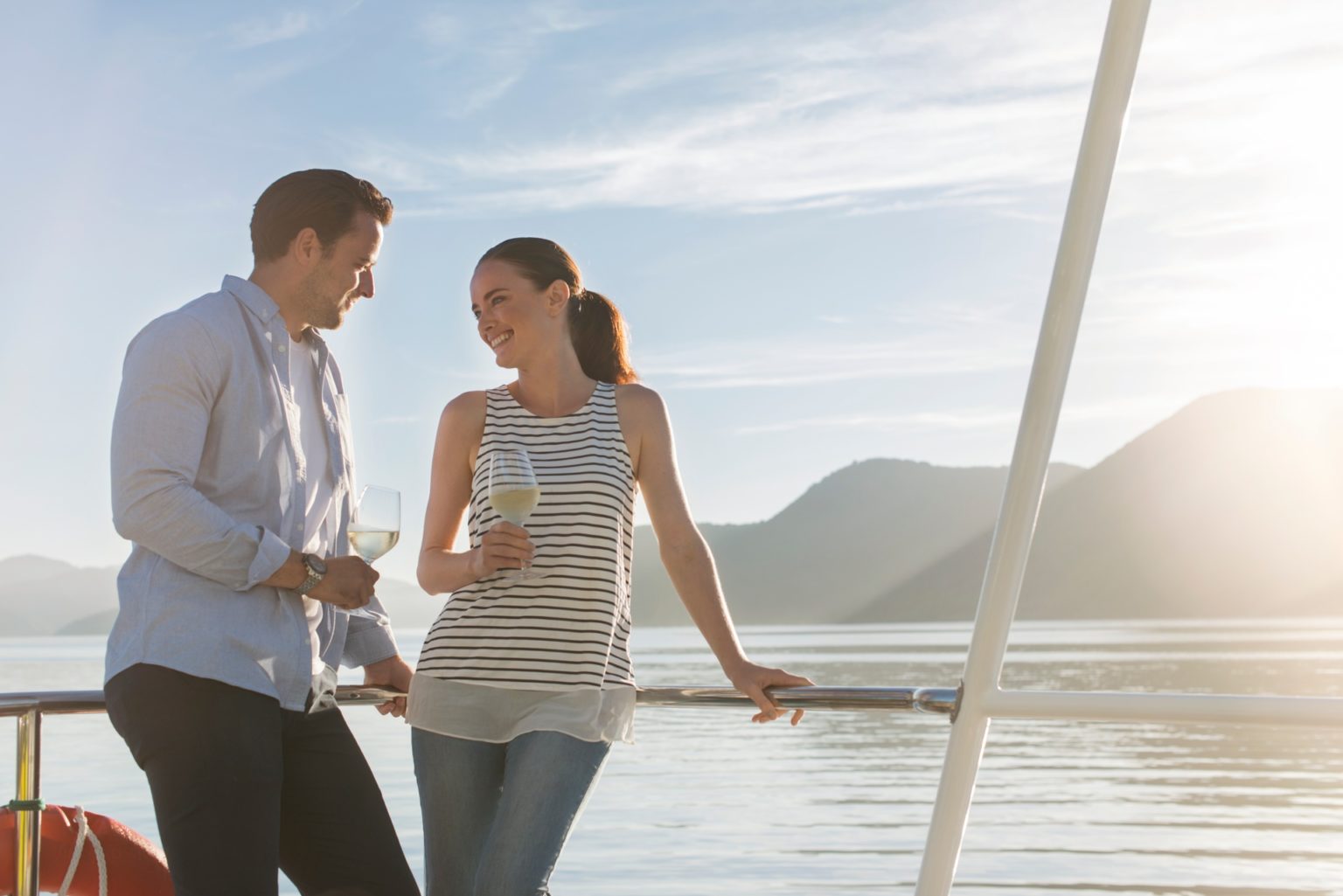 A couple enjoying a glass of wine on a yacht in the Queen Charlotte Sound.