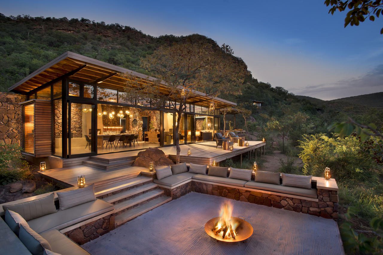 fire crackling on the outside main deck at marataba trails camp with main lodge beautifully lit up in the background