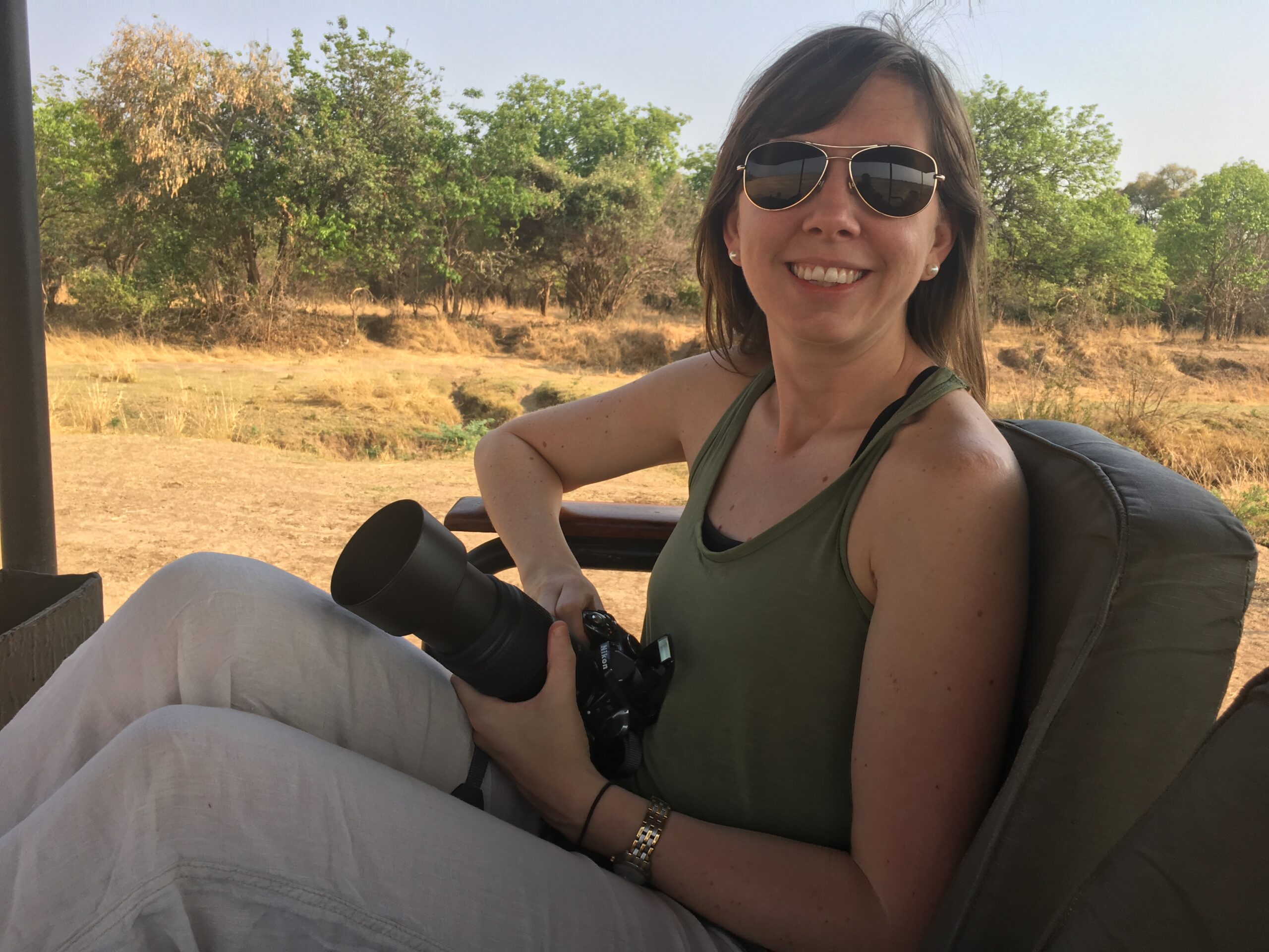 Our head of sales Jamie Mehrotra smiling in the seat of a safari vehicle while on game drive. 