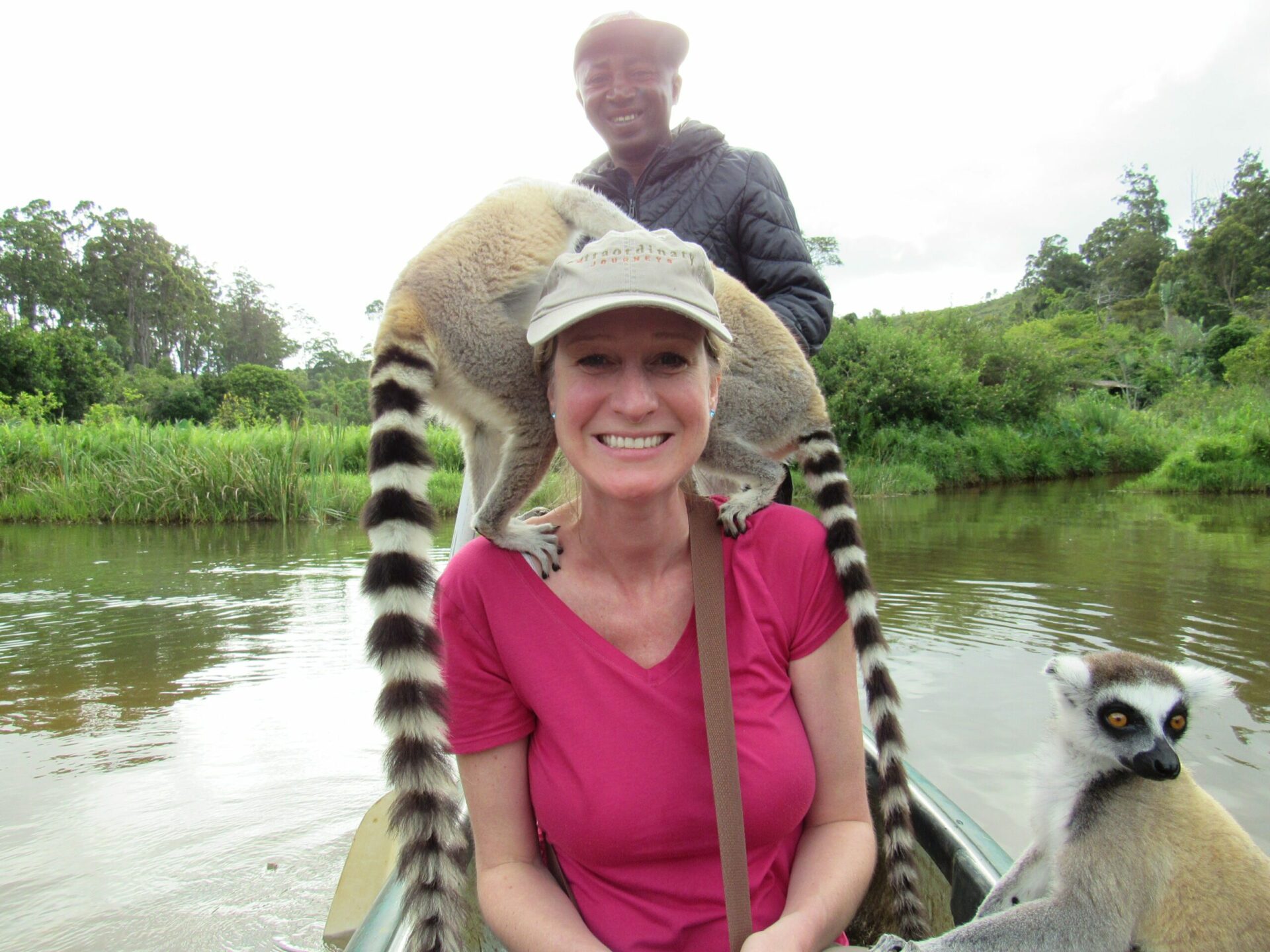Madagascar, woman with two lemur on her on a boat