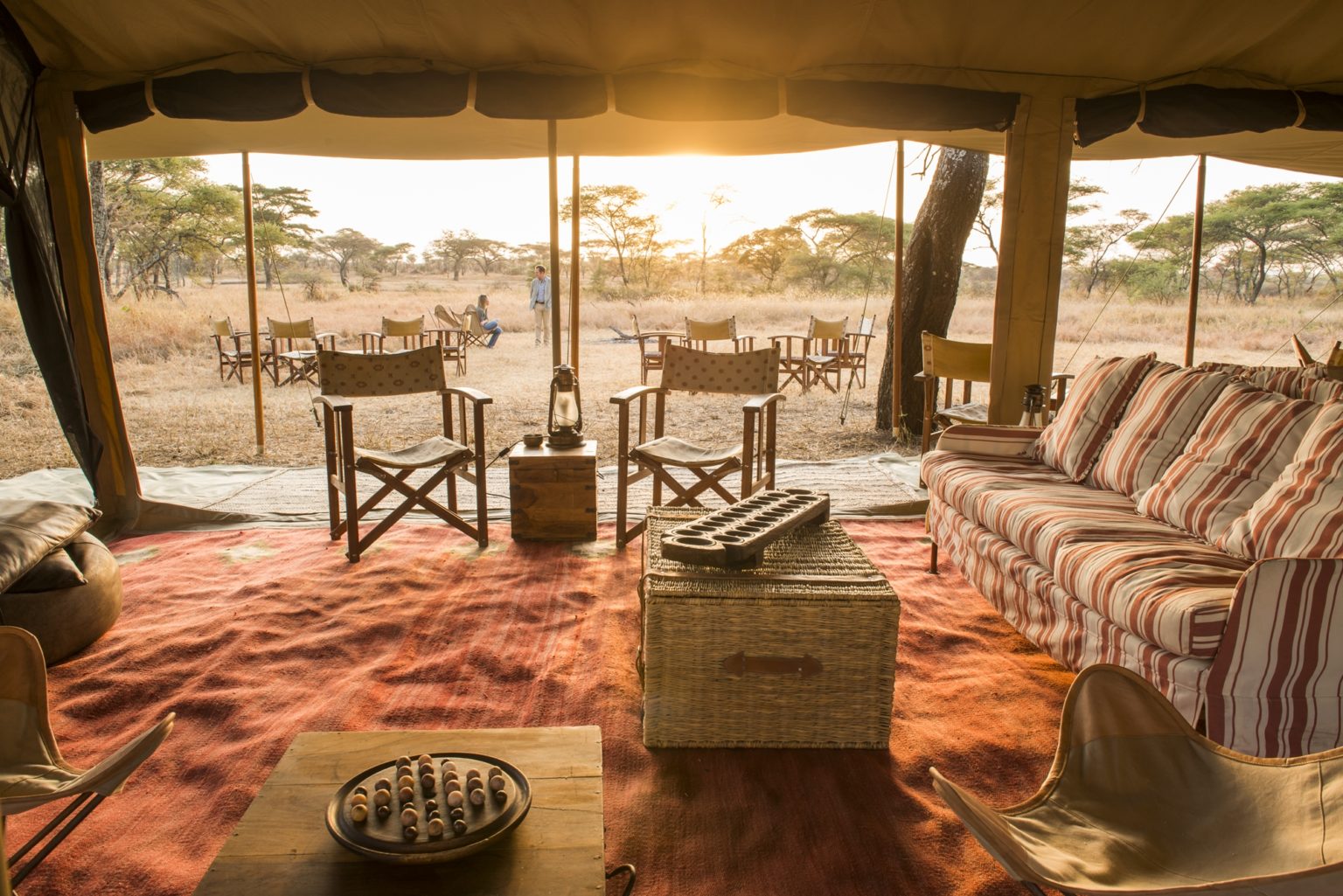 view from the inside of a tented safari camp at sunset
