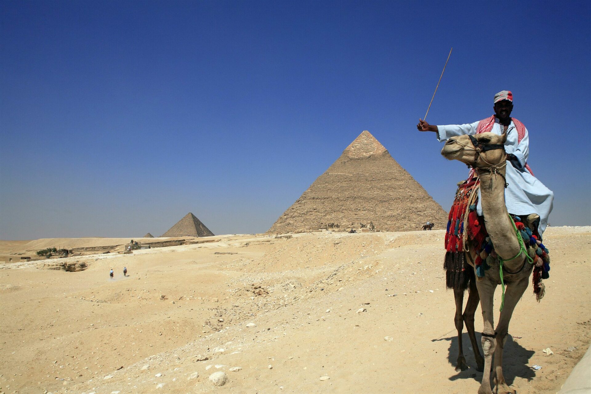 Great pyramids in background and Egyptian man on camel in foreground seen on Egypt safari