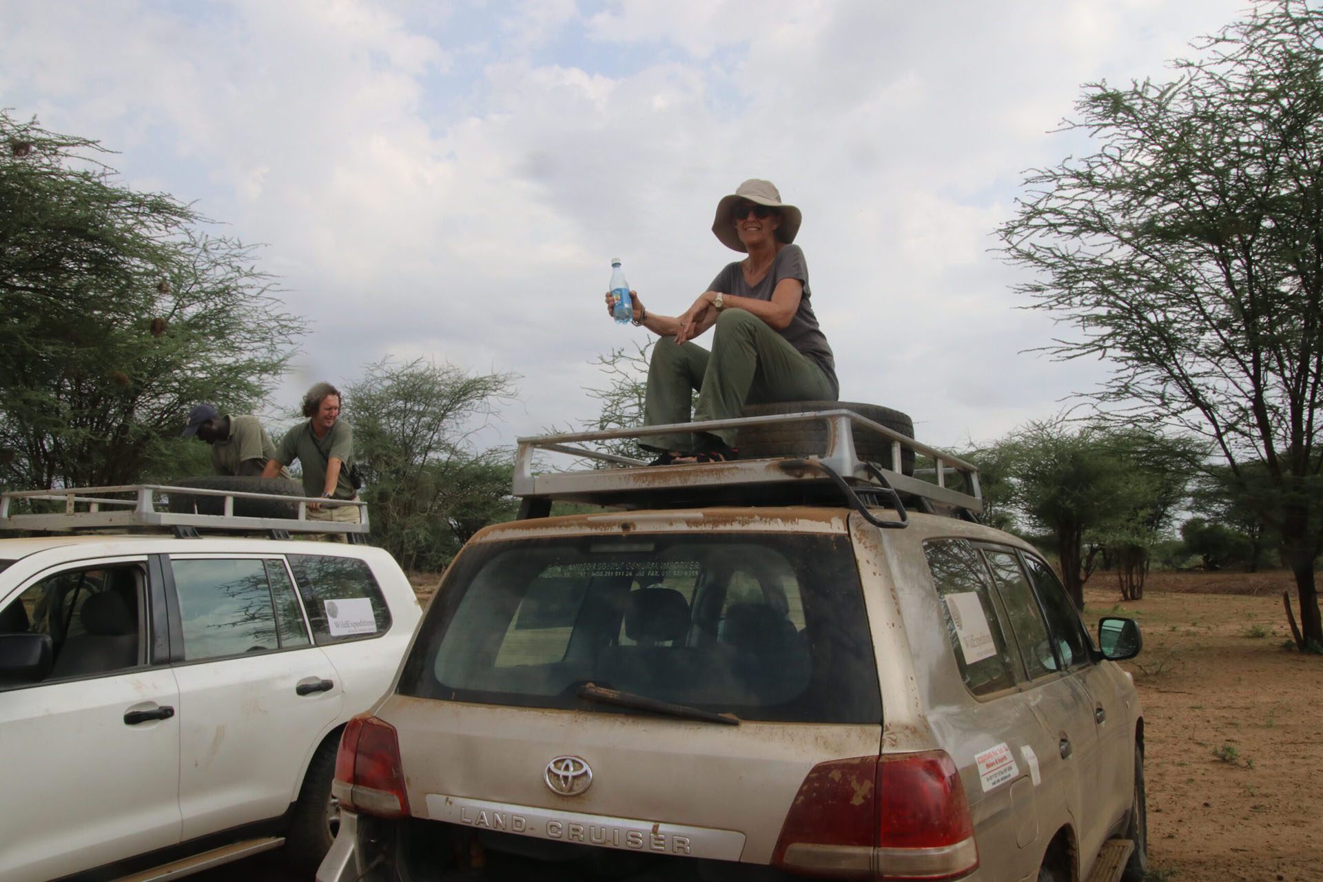 a woman sitting on the roof of a vehicle.