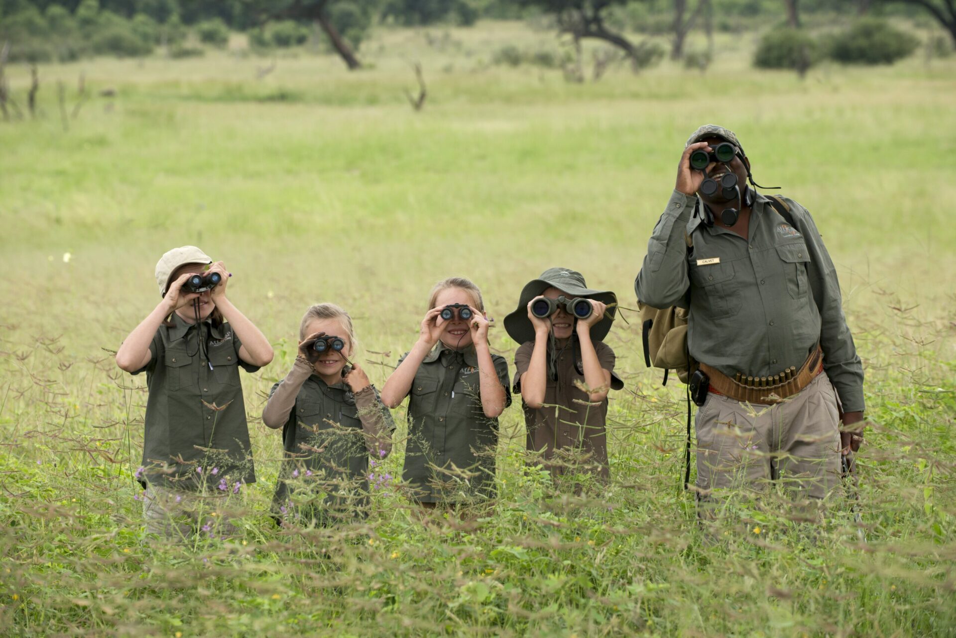 African Bushcamps, guides and children looking through binoculars on a family safari at African Bushcamps Somalisa