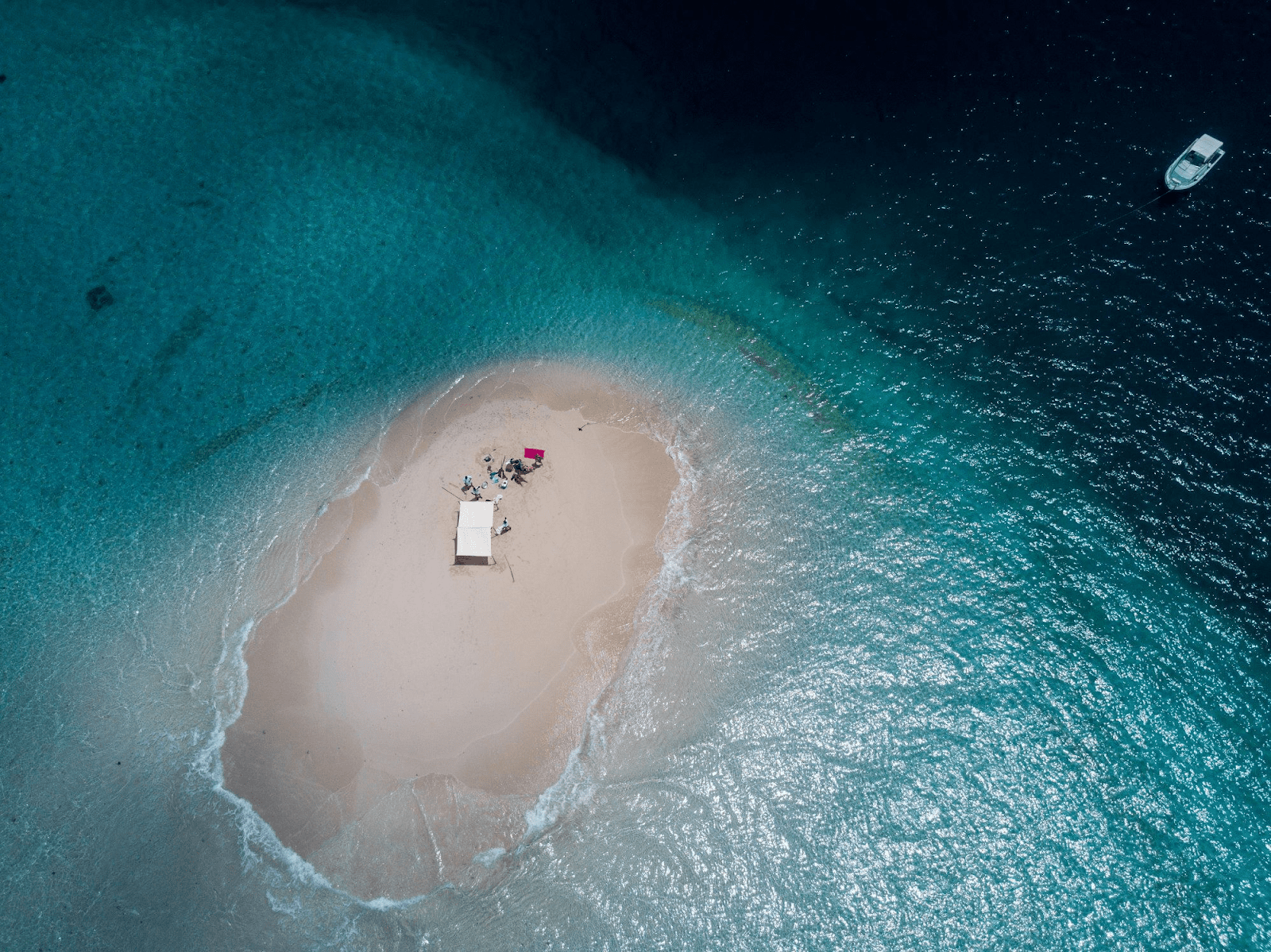 Aerial view of an islets with people exploring on it. 