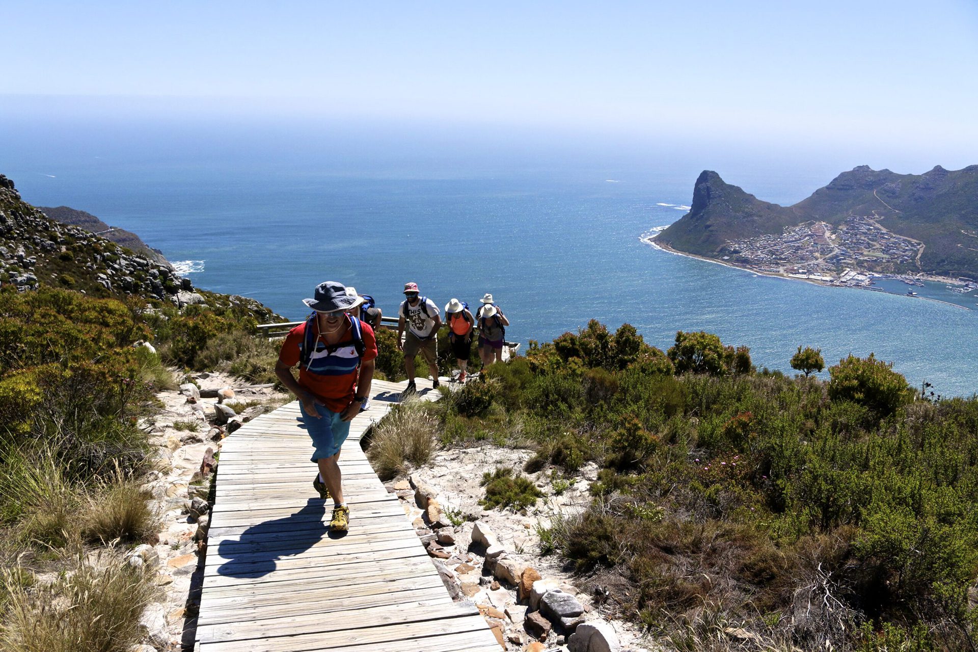 a group of people hiking up a wooden path.
