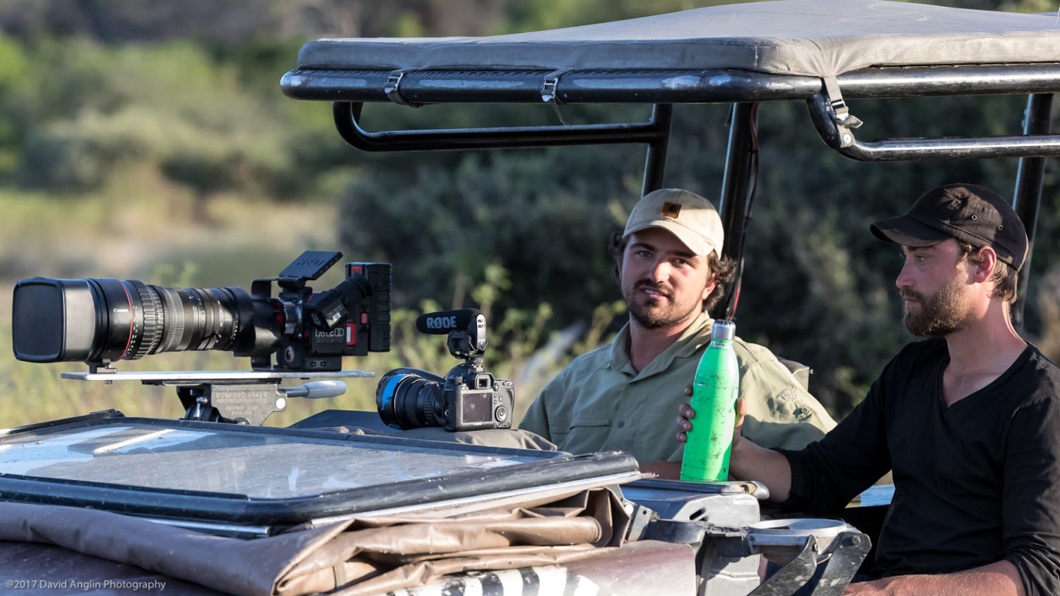 Guided conservation tour featuring a photographer and his guide in a safari vehicle