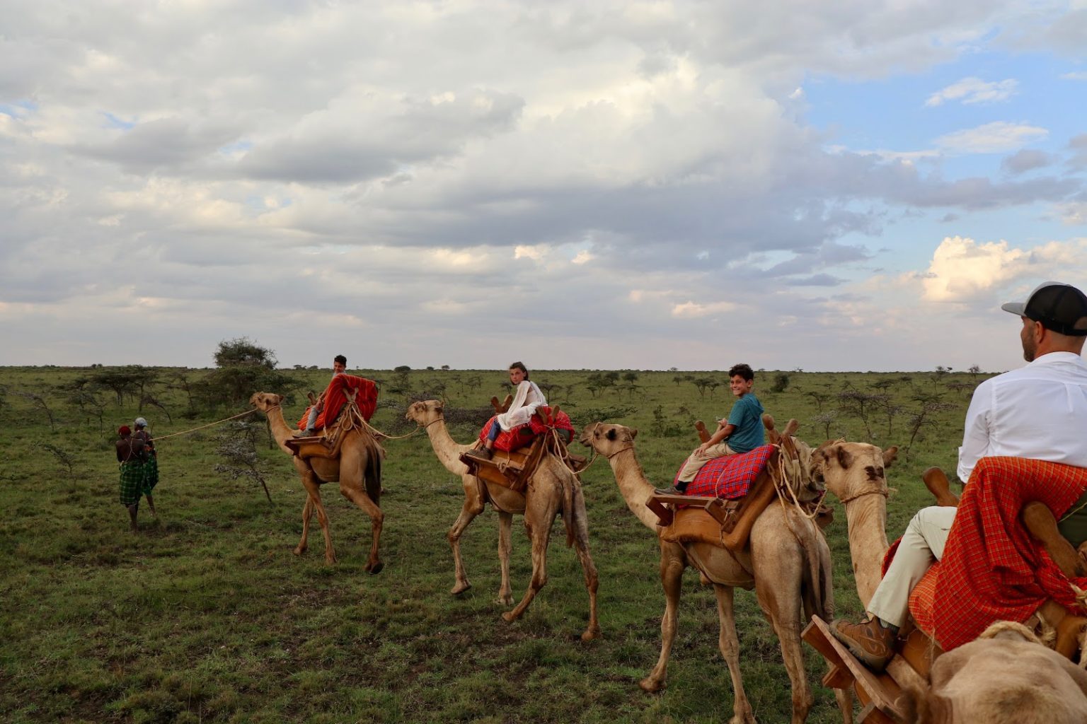 Mollie’s family rides atop camels on safari, following the lead of their guide