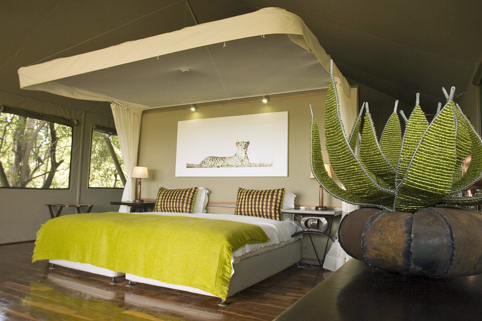 Chitabe Camp interior view of king bed bright chartreuse and cream decor on our off-grid Botswana safari
