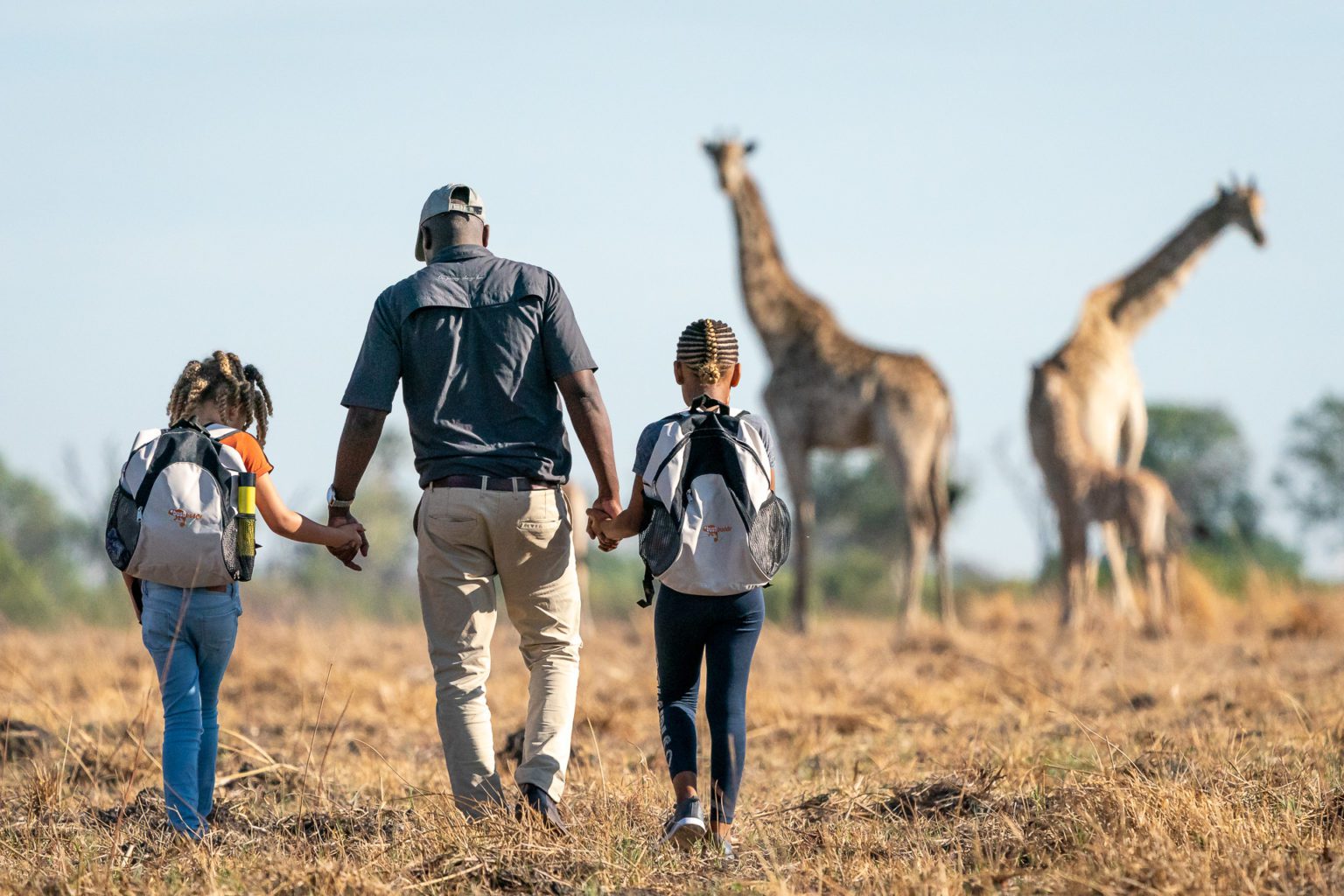 seba camp bush walk guide with two children on the best botswana safari. Family travel activities