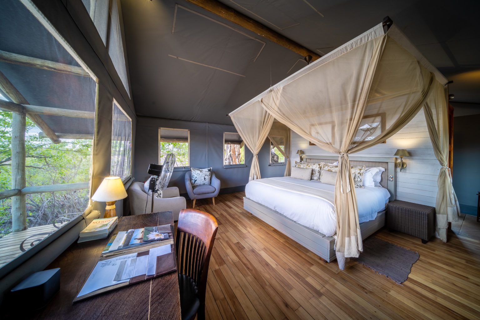 stay at seba camp interior room view of bed with nets drawn back on our off-grid Botswana safari