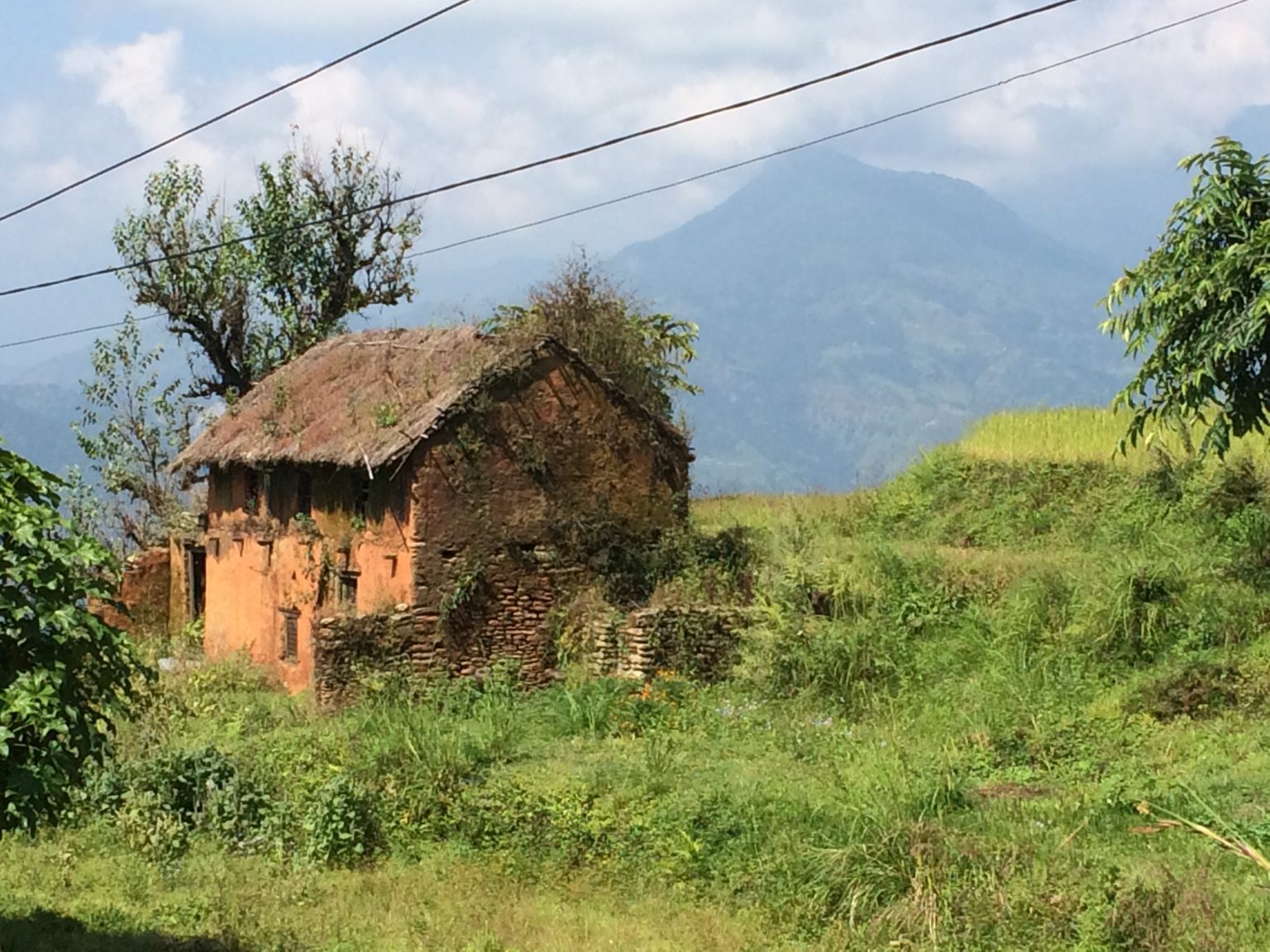 small house on nthe hillside with the mountains in the background