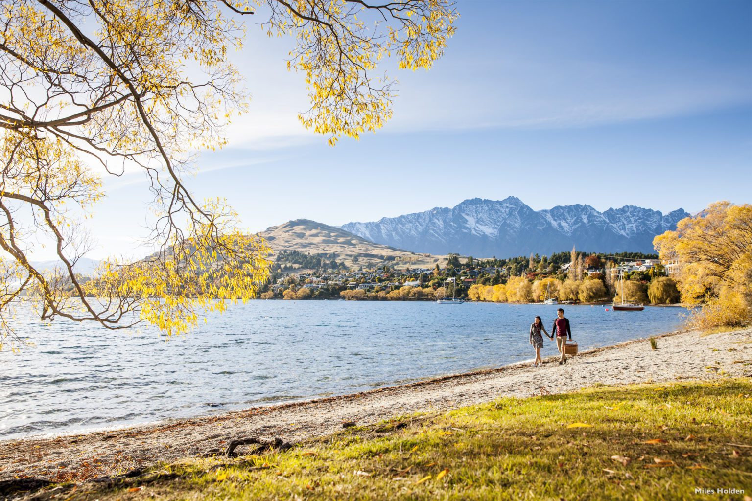 Two people walking along the Queenstown Trail next to Lake Hayes