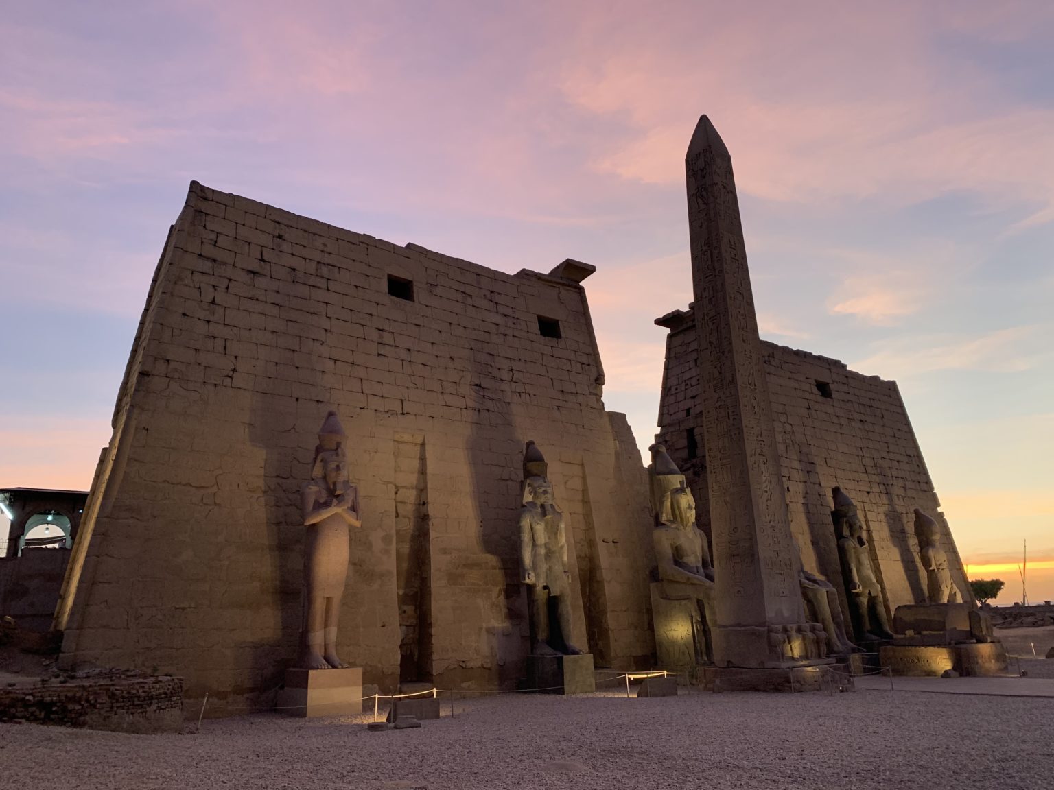 Luxor temple column and statues at sunset