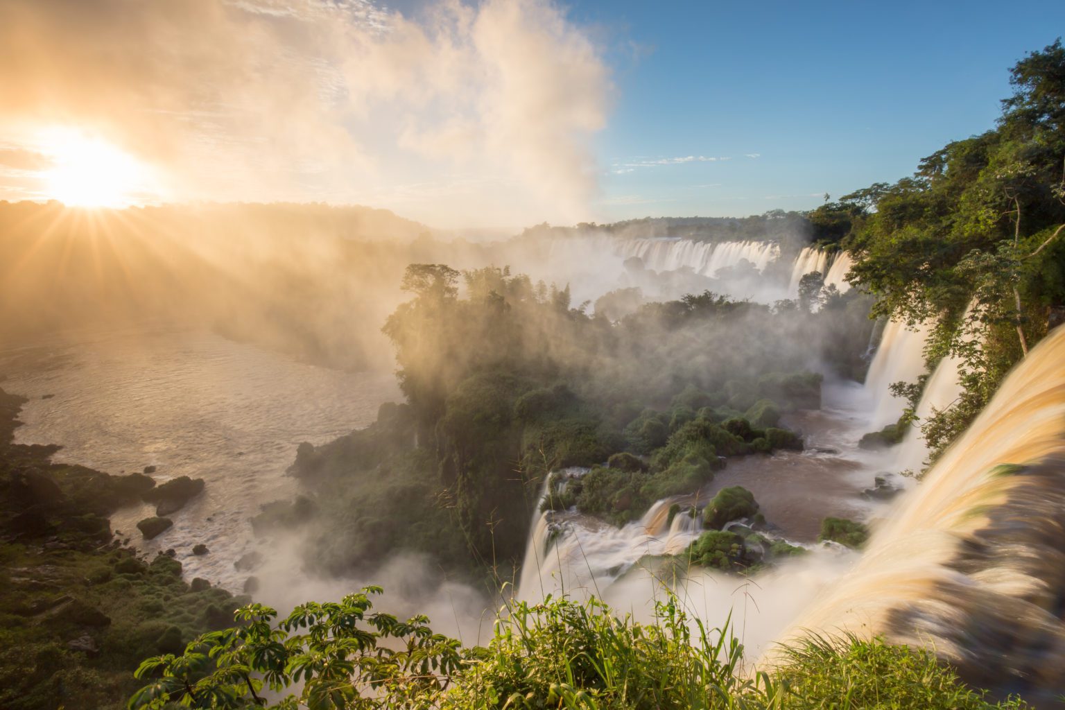 Sunrise over the falls with gushing water, greenery and gorgeous sky