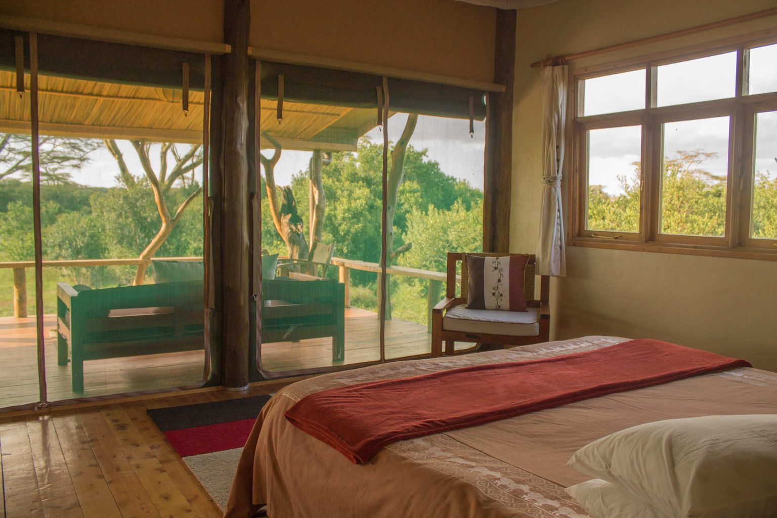 interior of ol pejeta safari cottage bedroom showing the end of the bed and porch