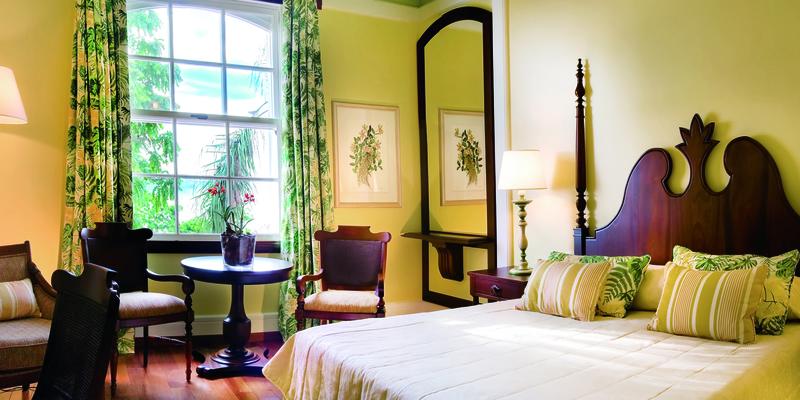 Hotel room with green walls and dark wood furniture