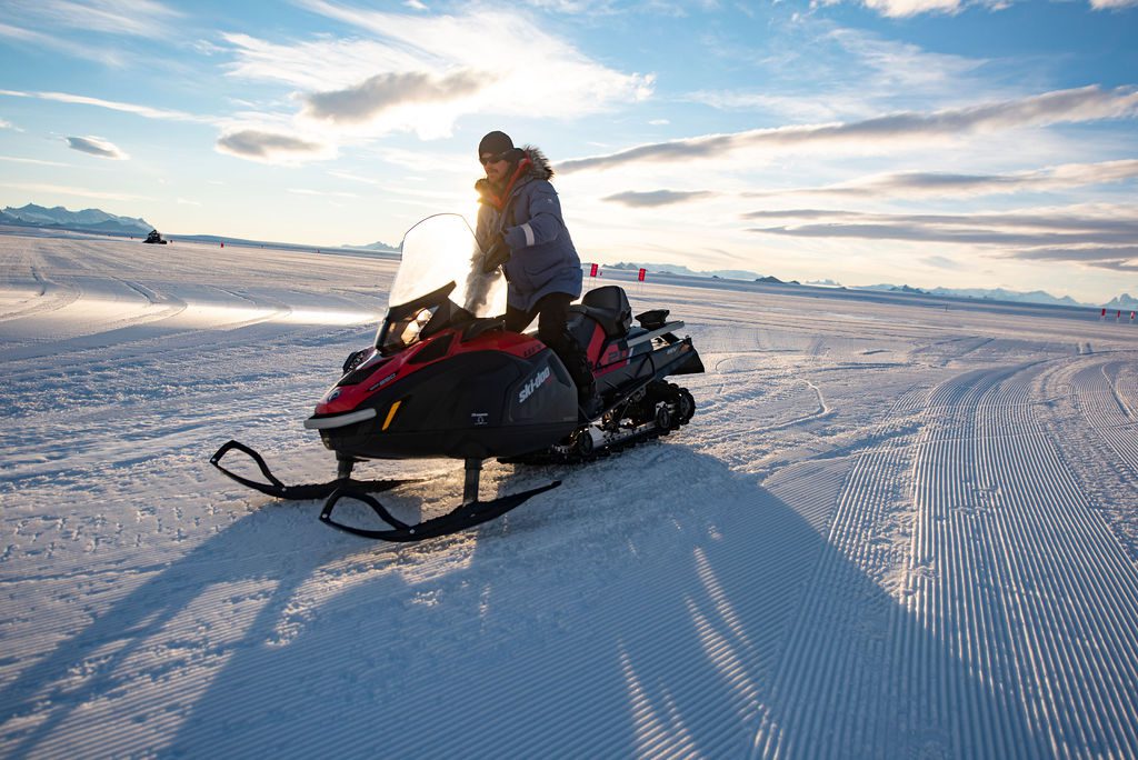 person riding a skidoo across the ice