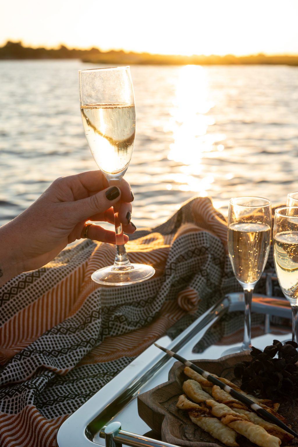 Chobe Princess boat cruise classes of champagne at sunset
