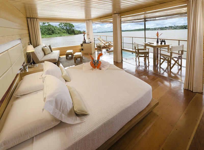 Cruise cabin with large windows and outdoor table and Jacuzzi