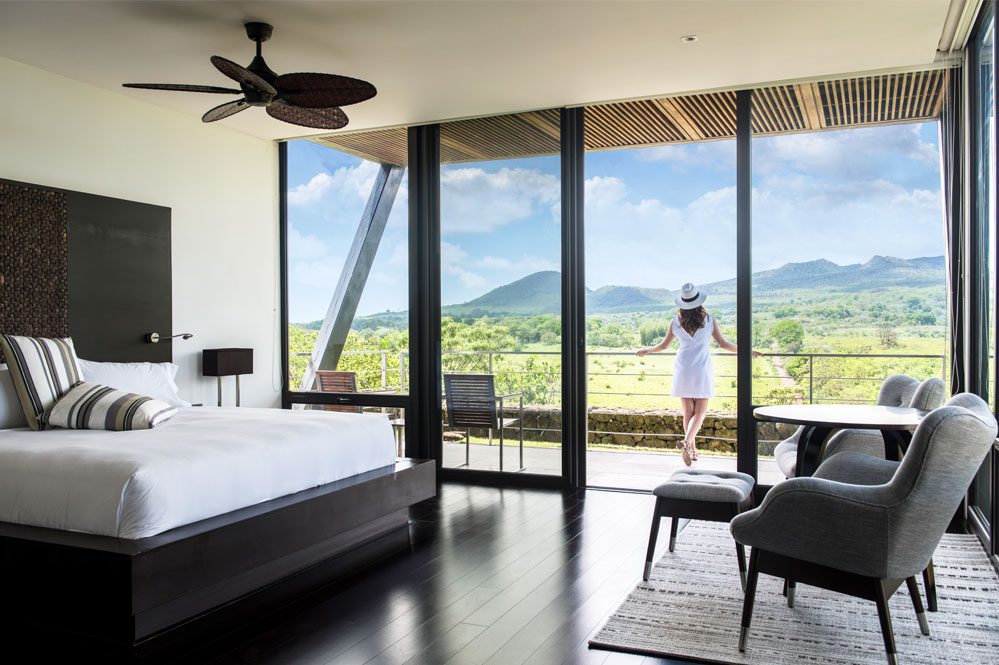 view of a bedroom with a woman standing on balcony on Ecuador holiday