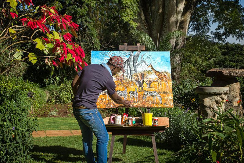 Tanzania with Young Kids, A local artist paints his canvas in the gardens at Gibb's Farm