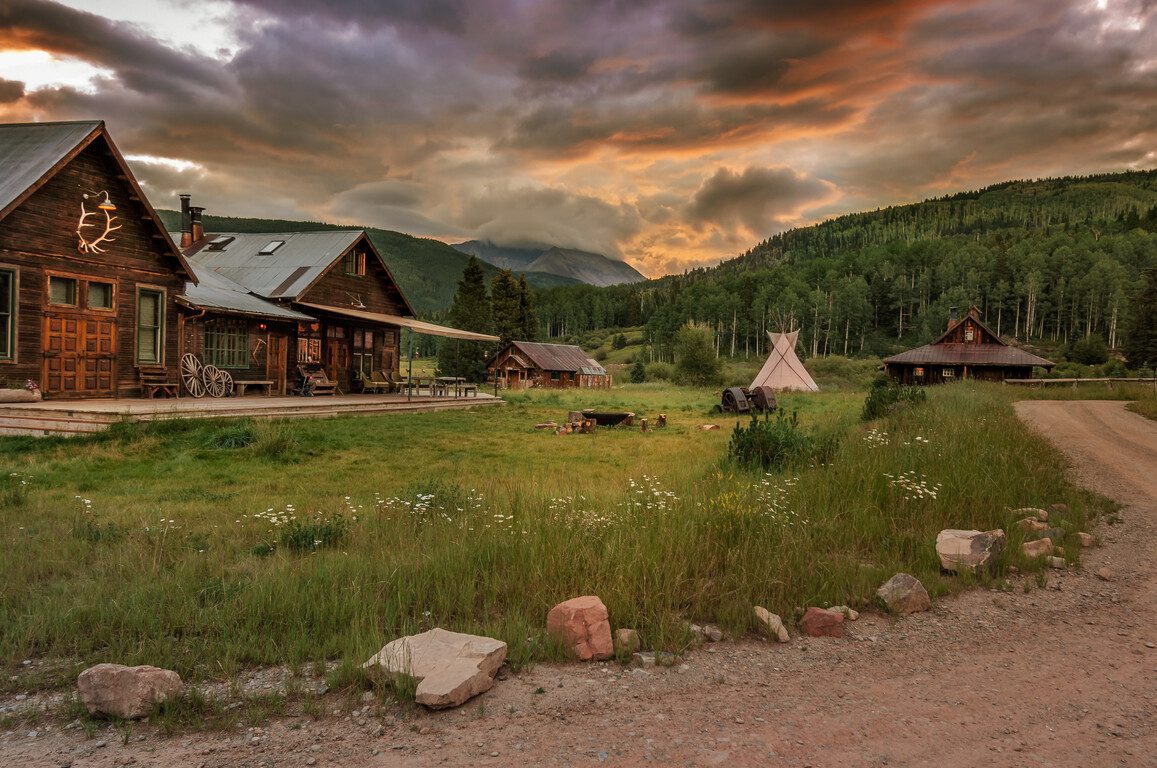 wood cabins and a teepee at sunset in colorado
