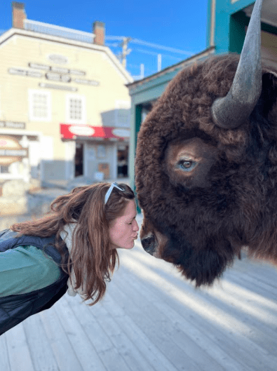 Serious Wildlife Seekers will Love a Quiet Spring or Fall Weekend in Jackson Hole, A Woman Mimics Kissing a Stuffed bison