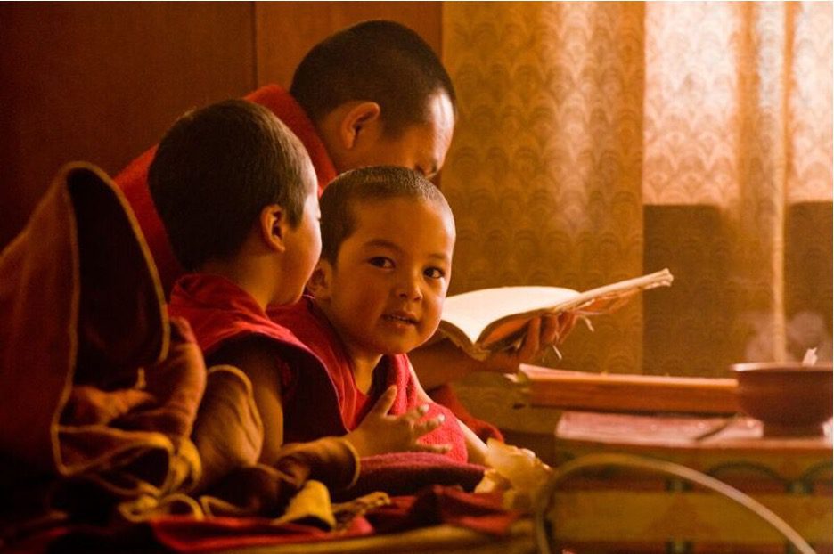 buddhist children in red robes learning