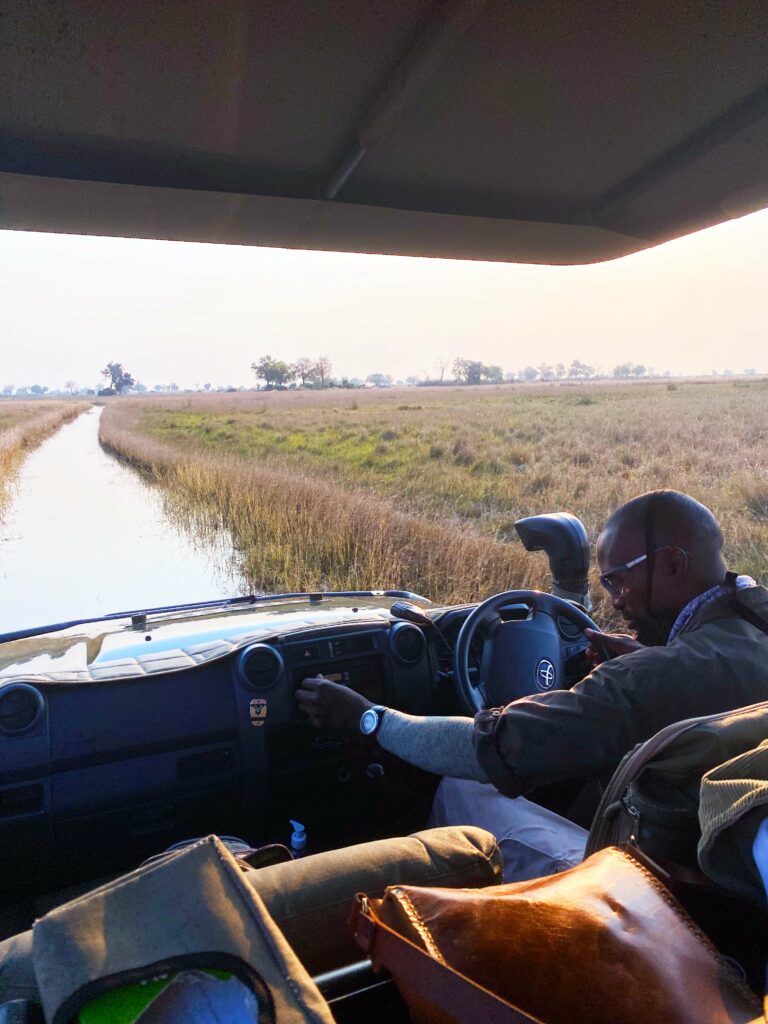 a man driving a vehicle down a road next to a river.