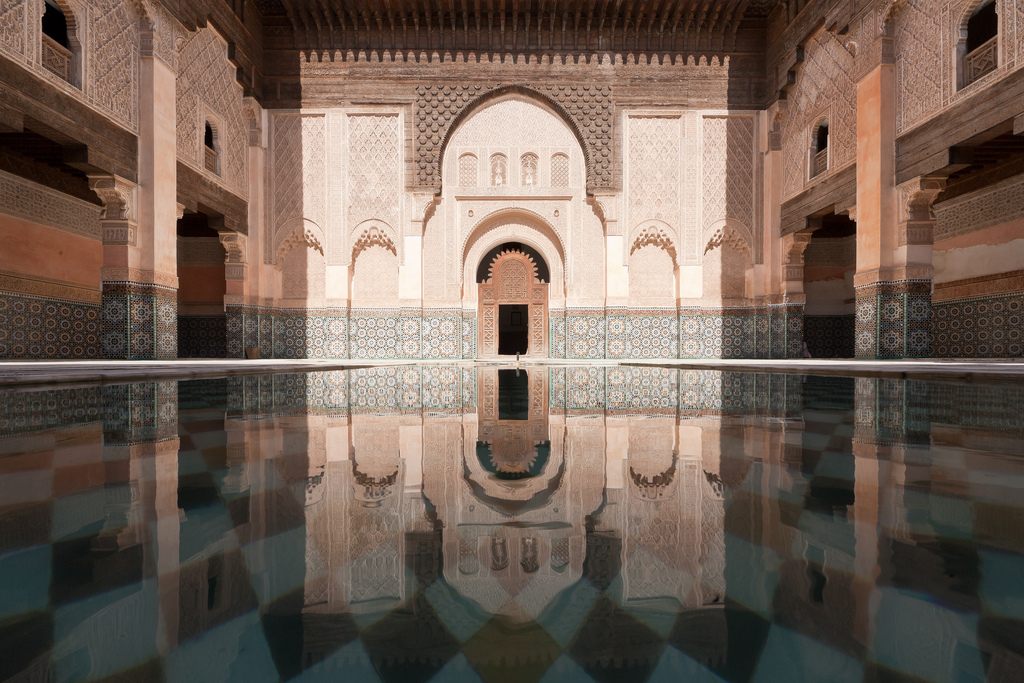 a reflection of a building in a pool of water.