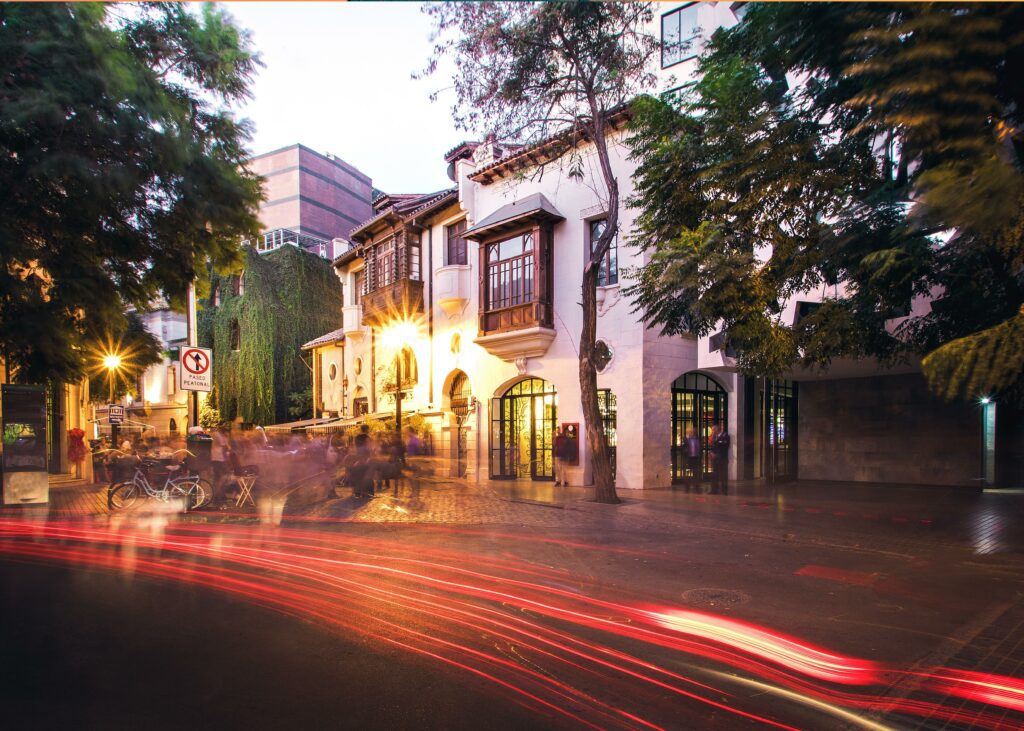 An over exposed image of cars lights passing a city corner in the Lastarria neighborhood of Santiago Chile