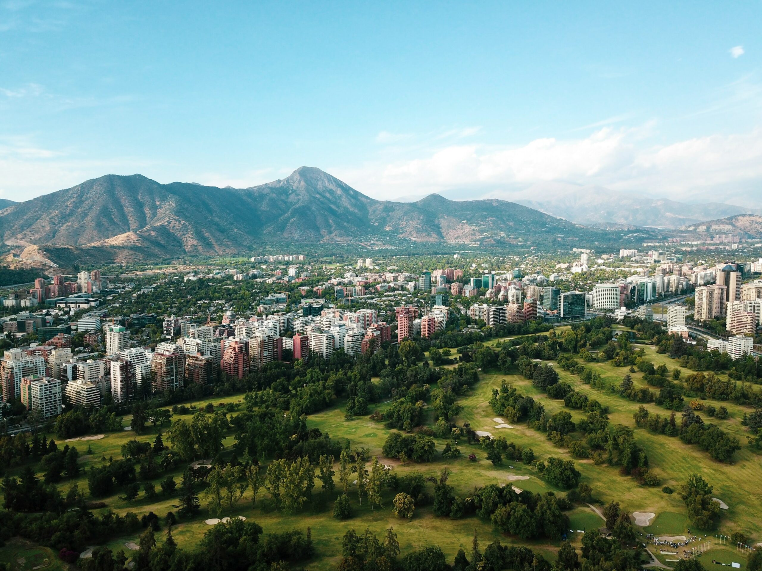 an aerial view of a city with mountains in the background.