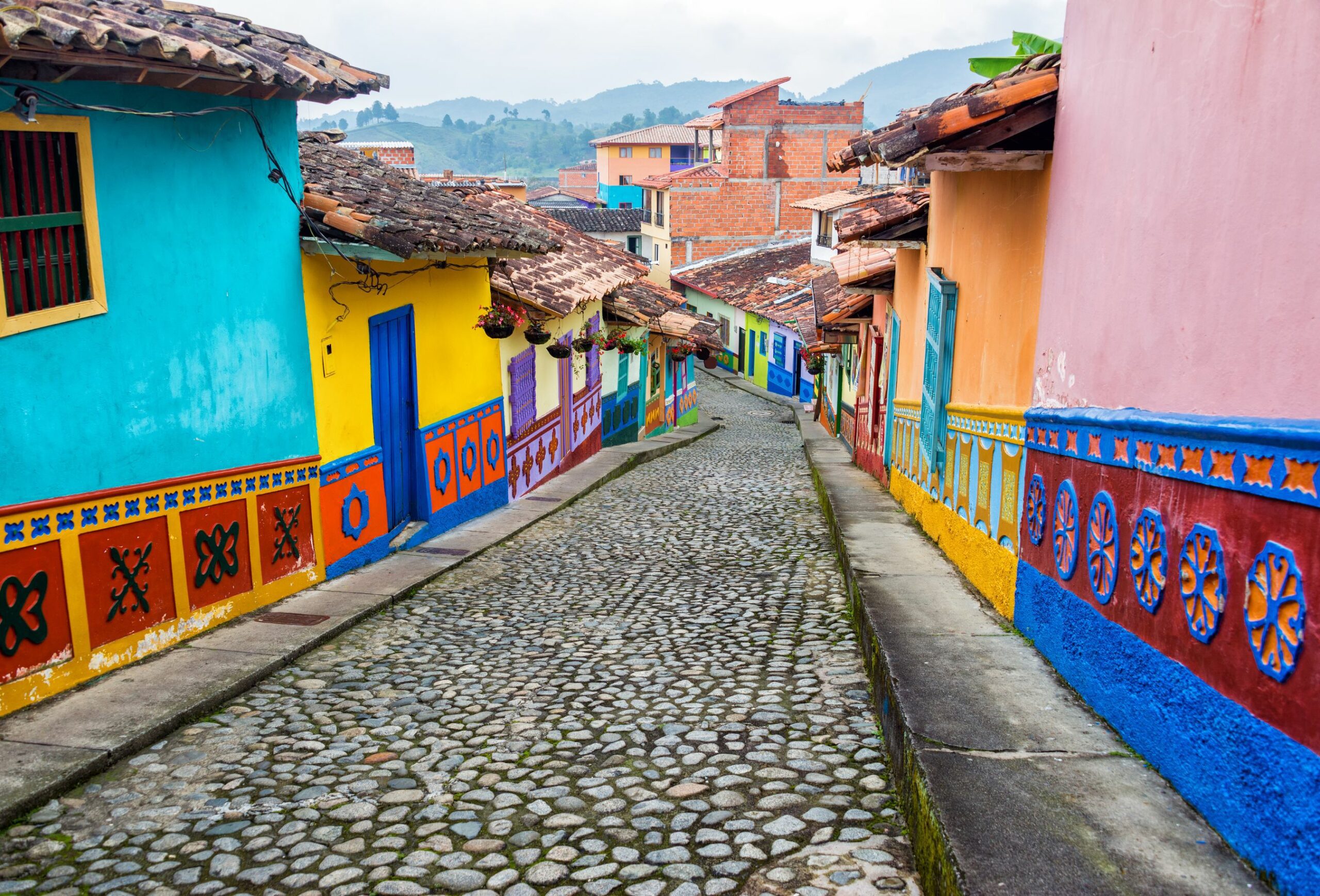 a cobblestone street with colorful houses on both sides.