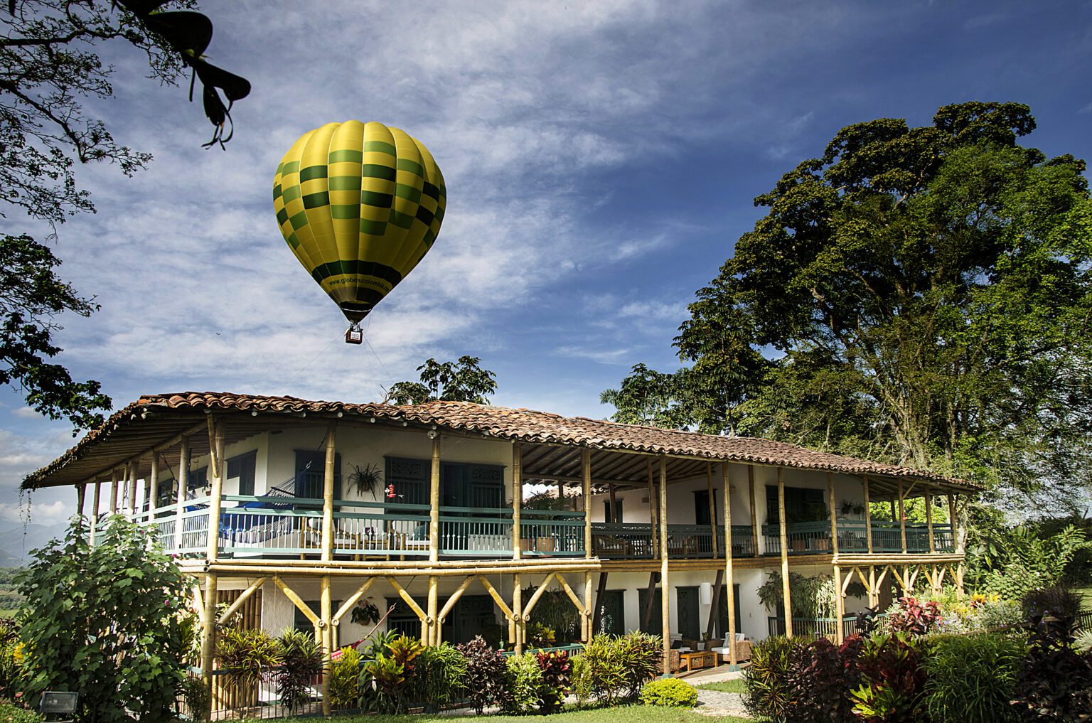 a house with a hot air balloon flying over it.