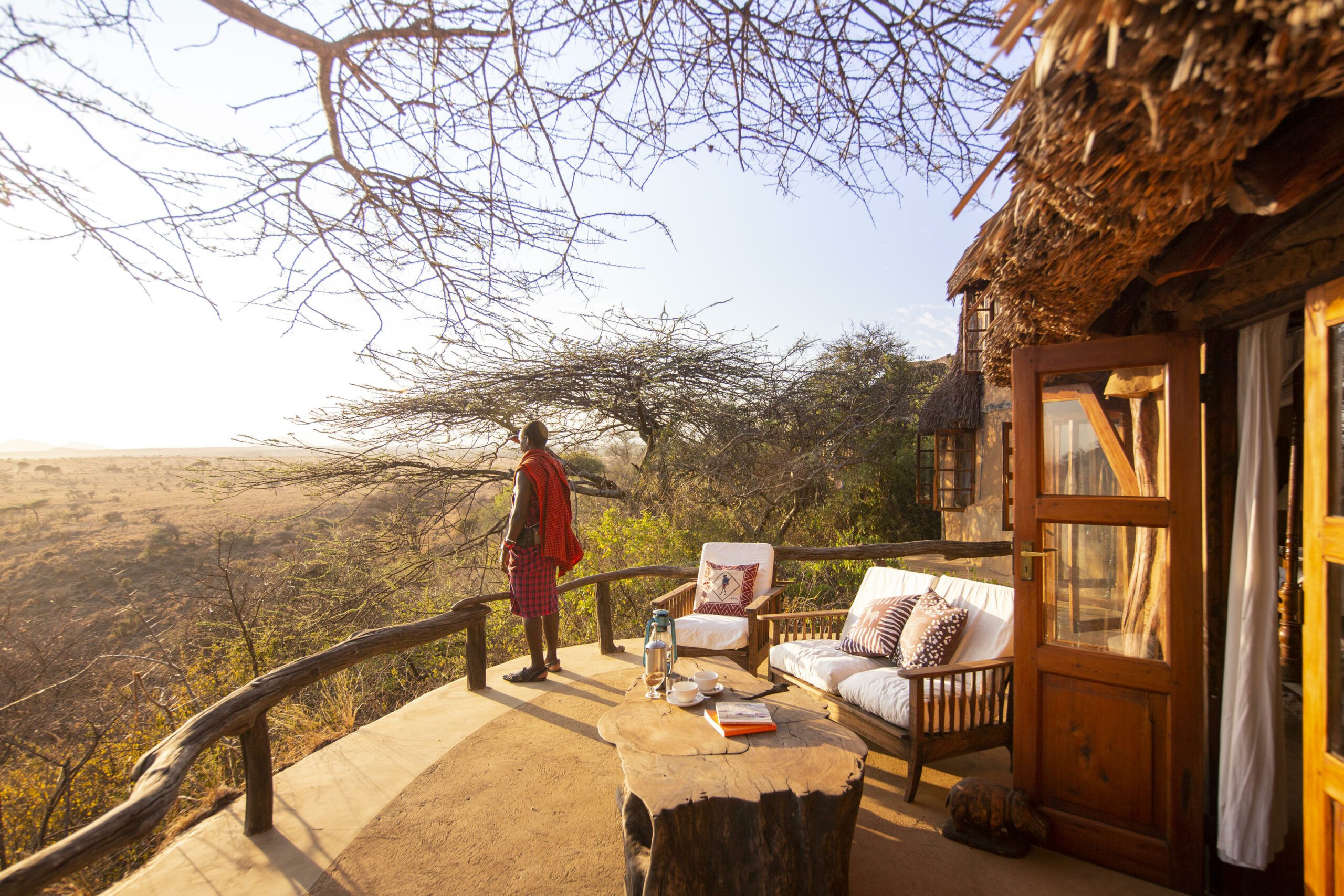 View of a Maasai man standing on a deck of a room at Lewa Wilderness Camp in Kenya