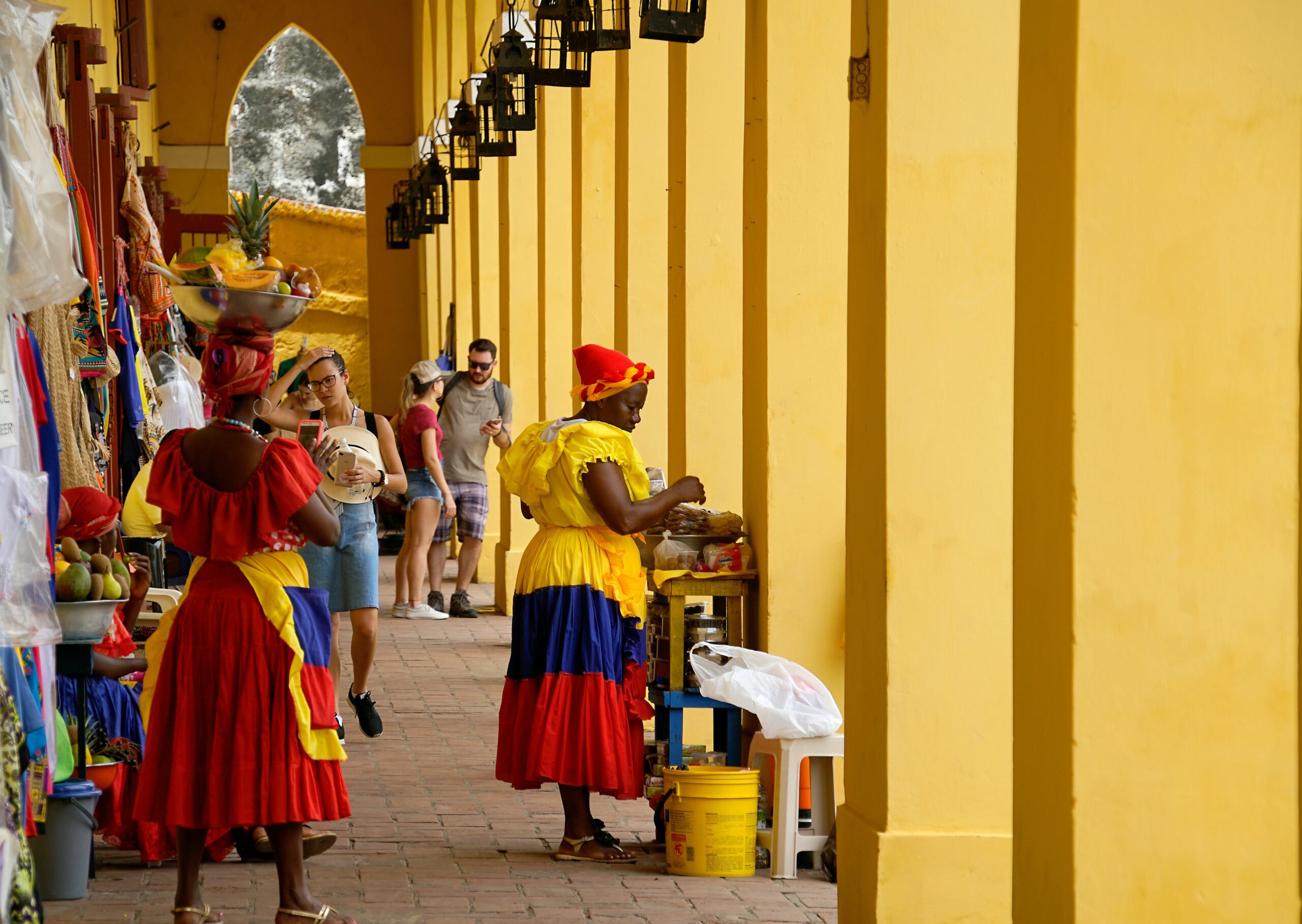 a group of people standing around a yellow building.